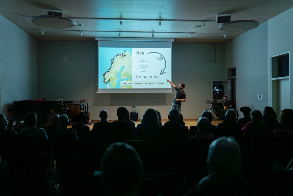 Benni Grams giving a travel talk to a full hall